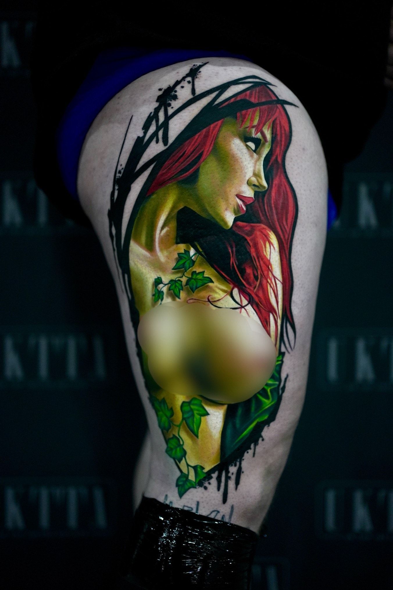 A woman has a tattoo of poison ivy on her leg.