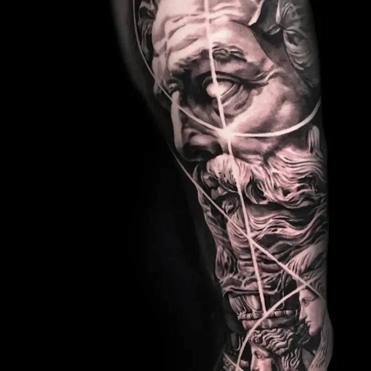 A black and white tattoo of a statue on a person 's arm.